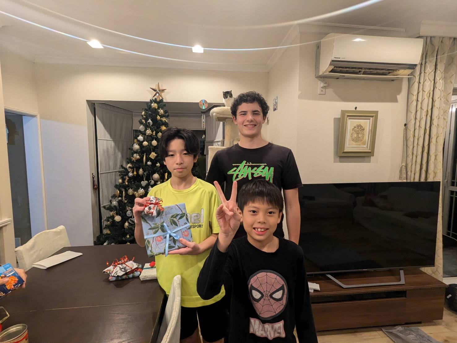 クリスマスツリーの前で兄弟と留学生