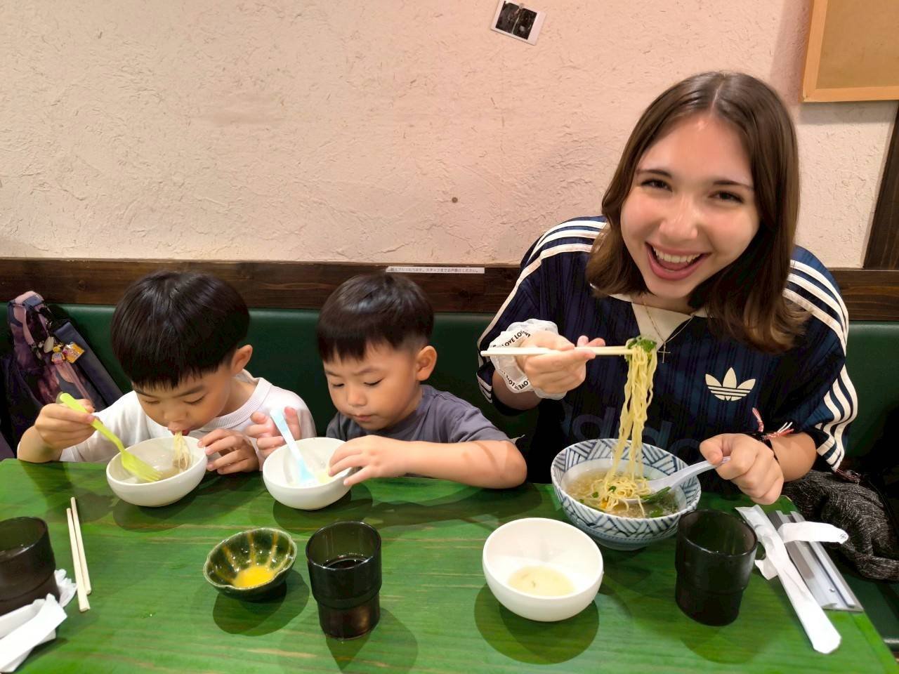 ラーメン店で留学生と日本人の子供たちが食事を楽しむ