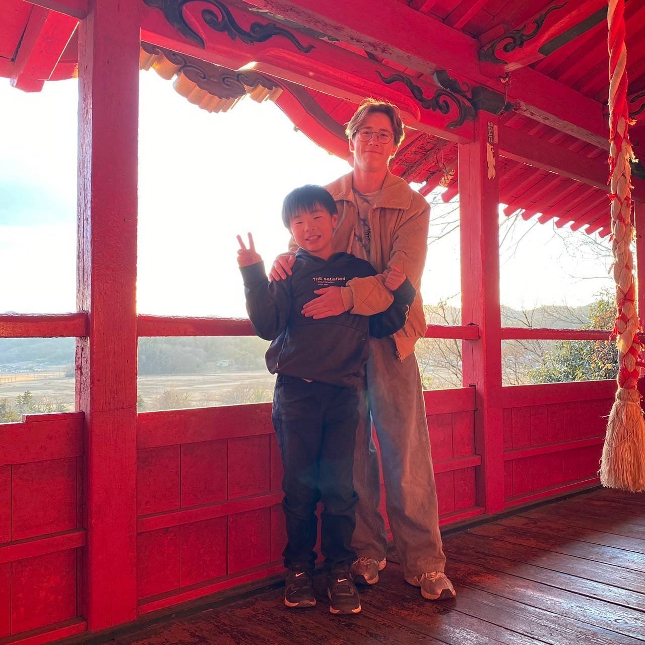 夕陽の朱塗り神社、留学生と日本人の弟