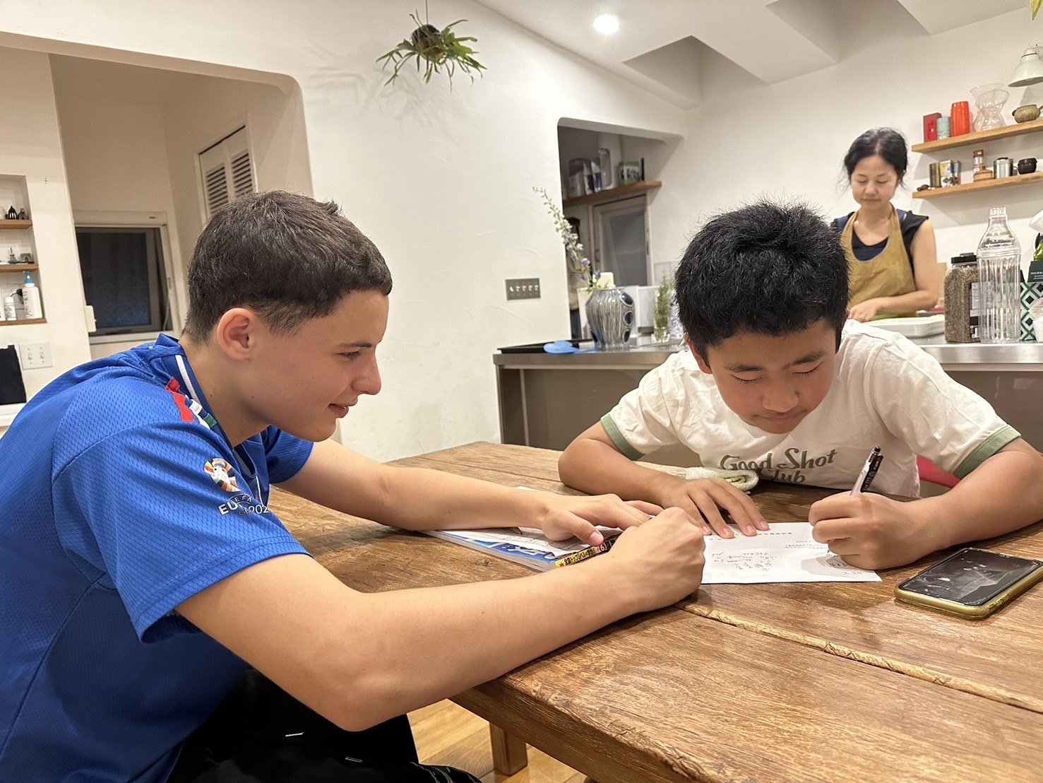留学生が日本人の弟に勉強を教えている様子