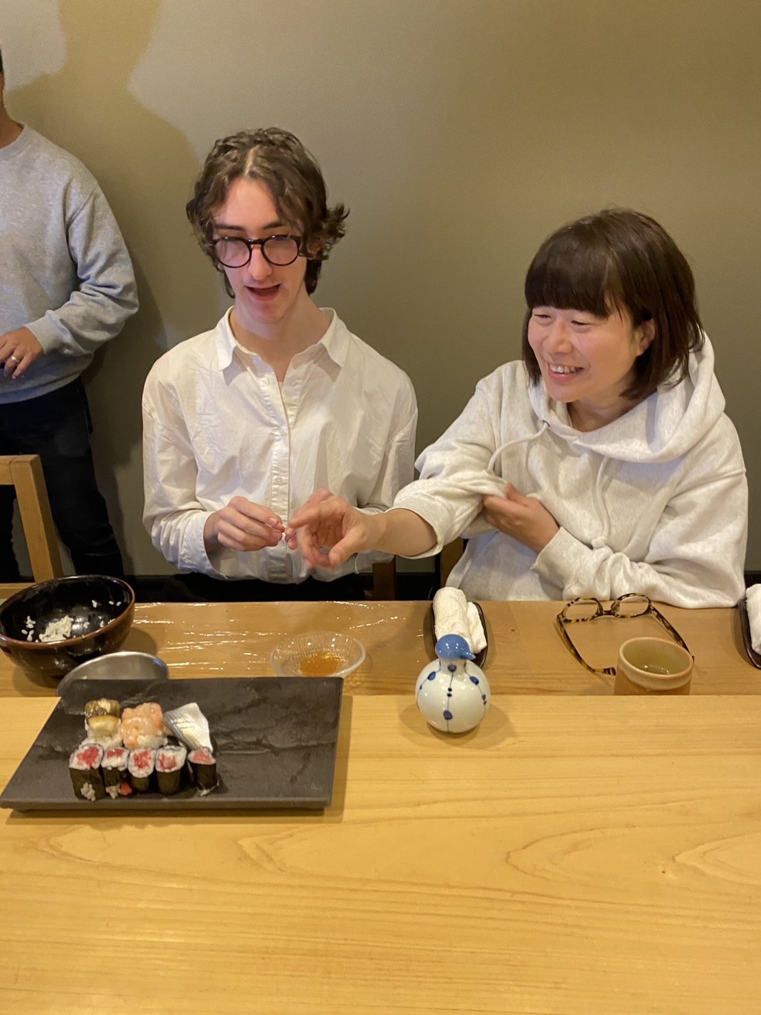 寿司カウンターでホストファミリーと爆笑する留学生